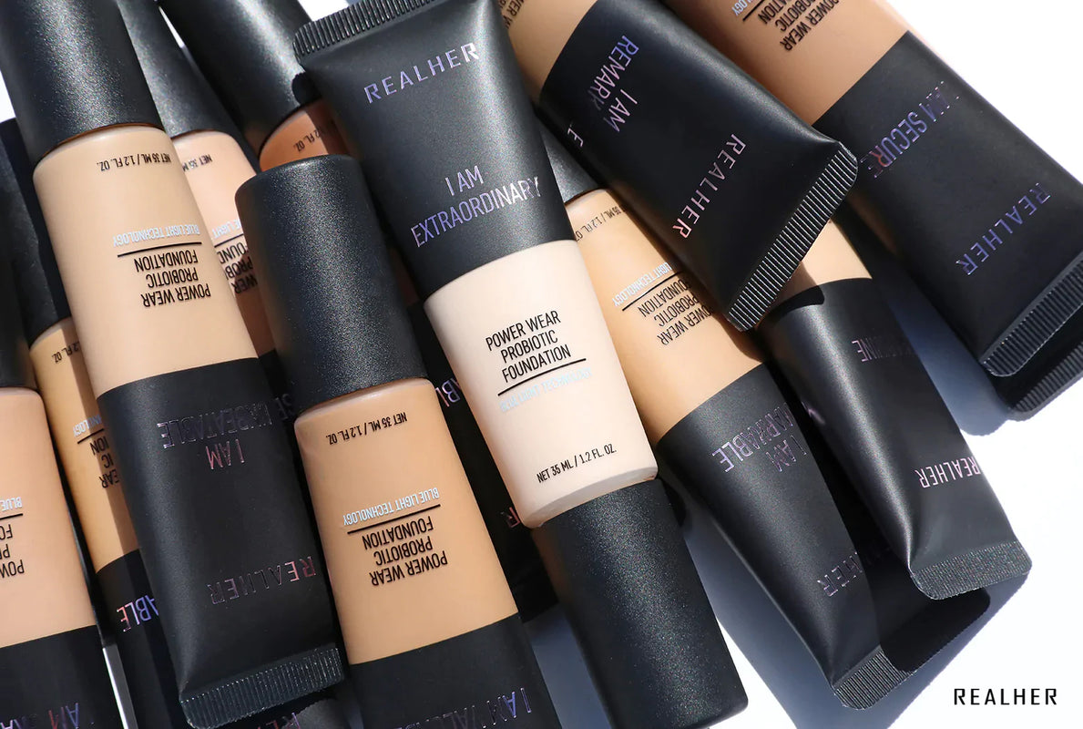 A collection of Realher probiotic foundation for skin, featuring various shades and packaging